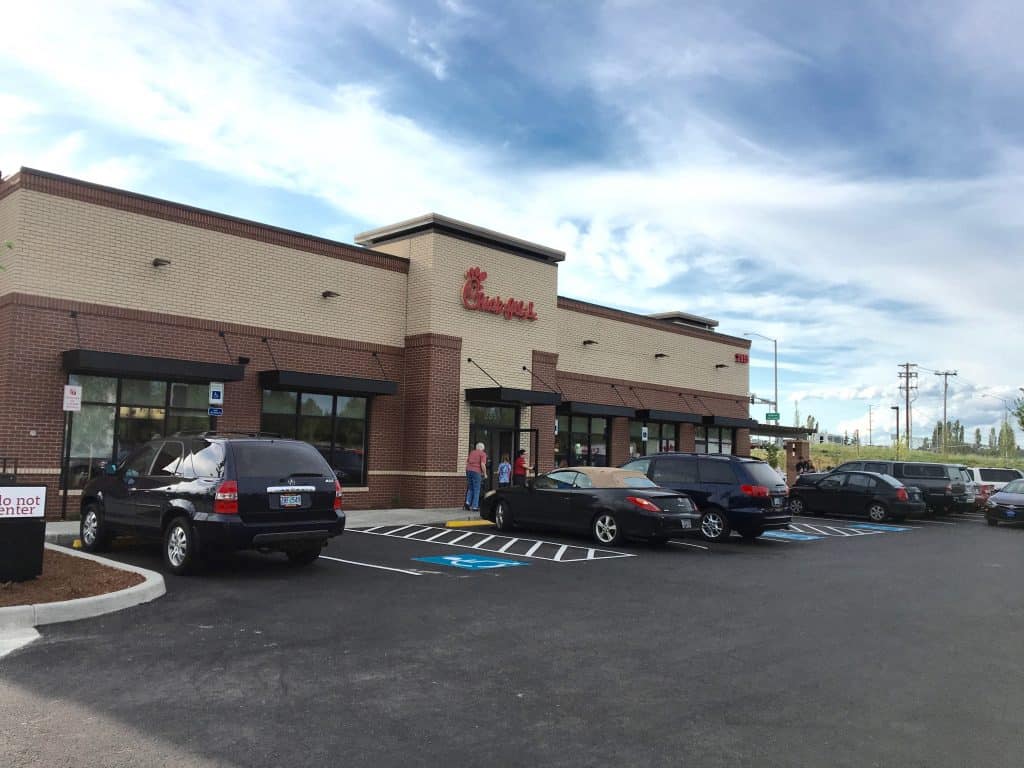 A Chick-fil-A restaurant with cars parked outside