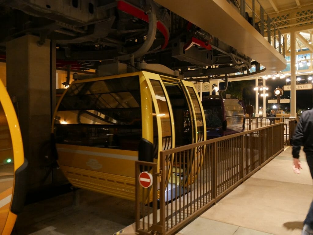 A Disney Skyliner car with open doors inside a station