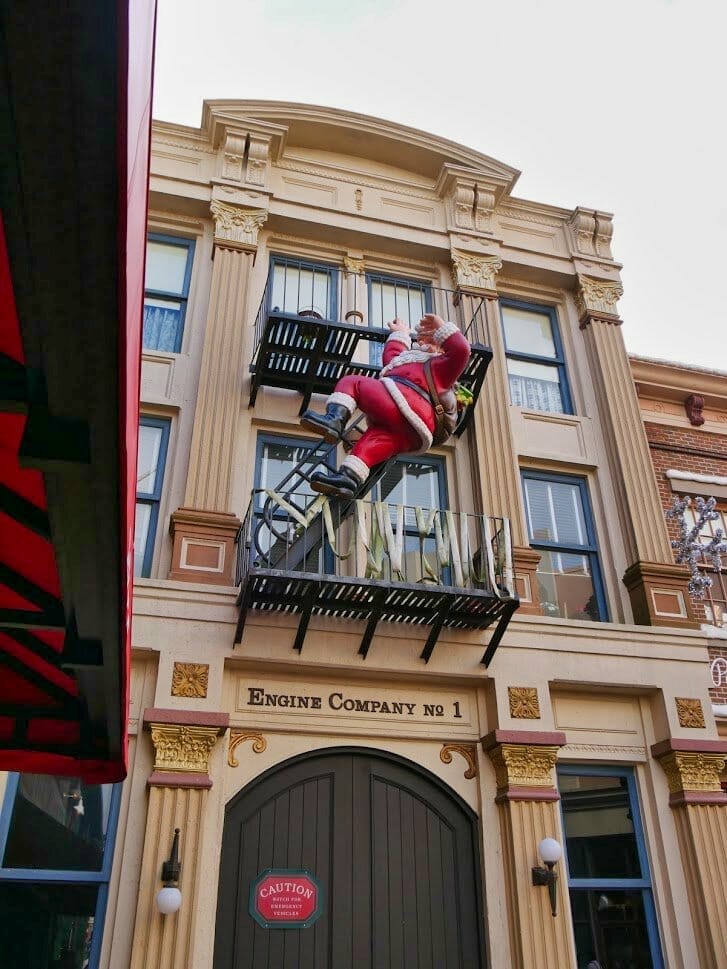Father Christmas climbing an emergency escape stair case outside a building at Hollywood Studios