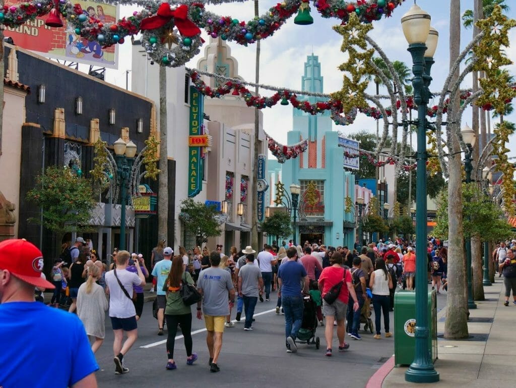 Main street in Hollywood Studios with Christmas decorations and people walking along