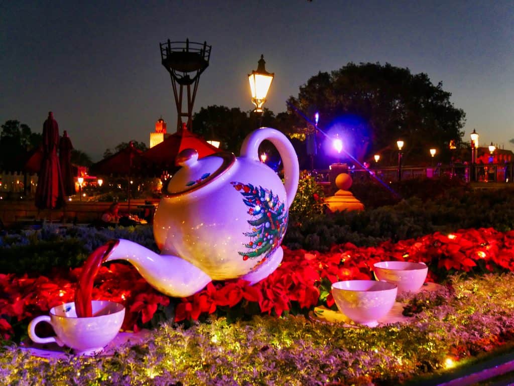 A teapot statue with a Chistmas tree painted on the side at Epcot at Christmas