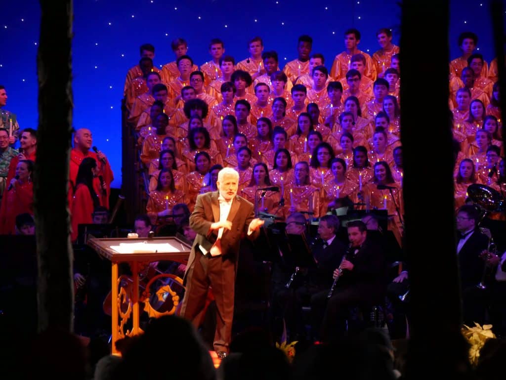 Candlelight Processional conductor with choir behind at Epcot, Disney World at Christmas