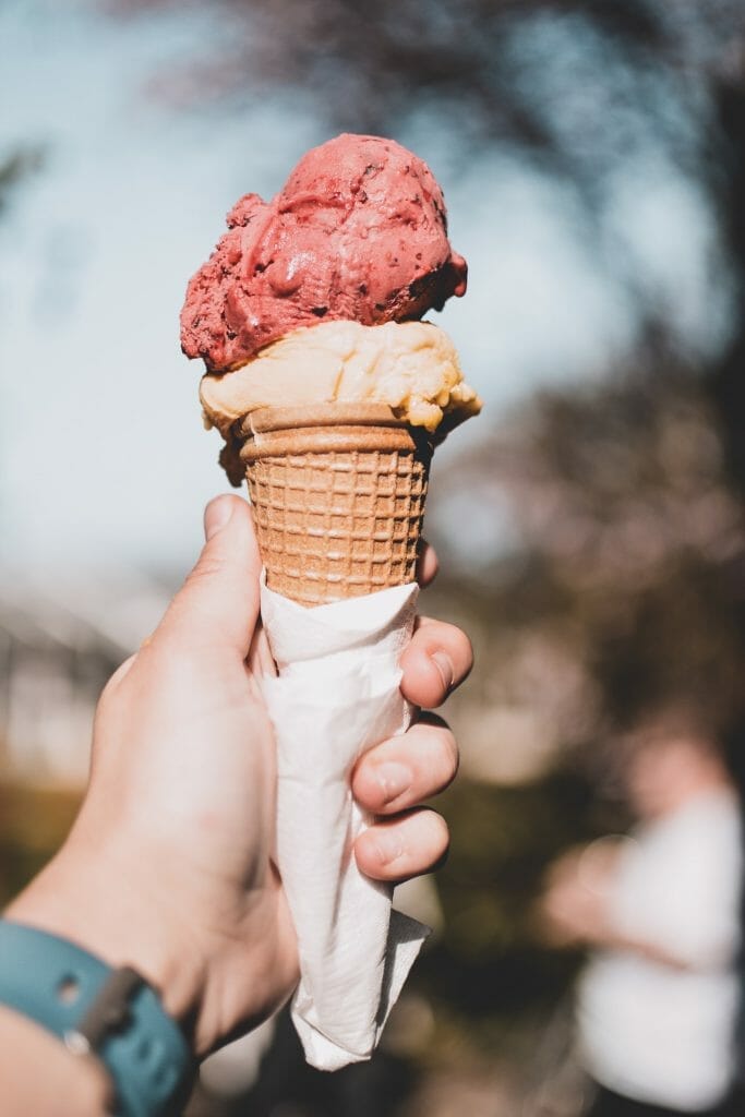 Hand holding ice cream cone with two scoops