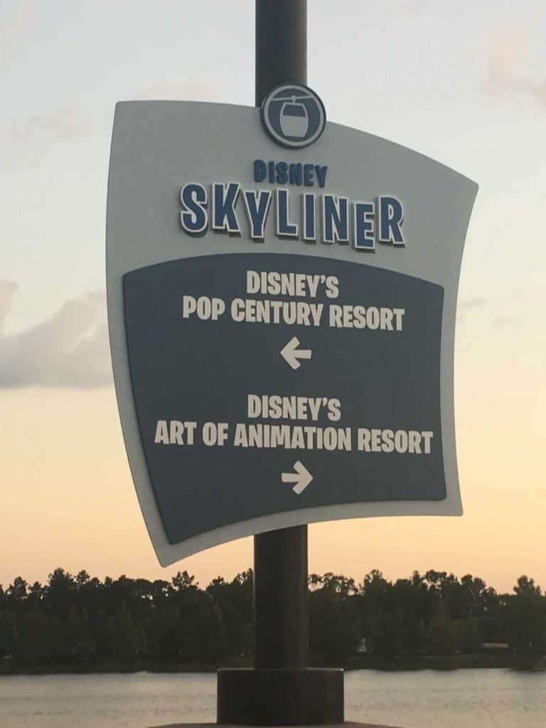 A signs saying "Disney Skyliner" with directions to Disney's Pop Century resort and Disney's Art of Animation resort