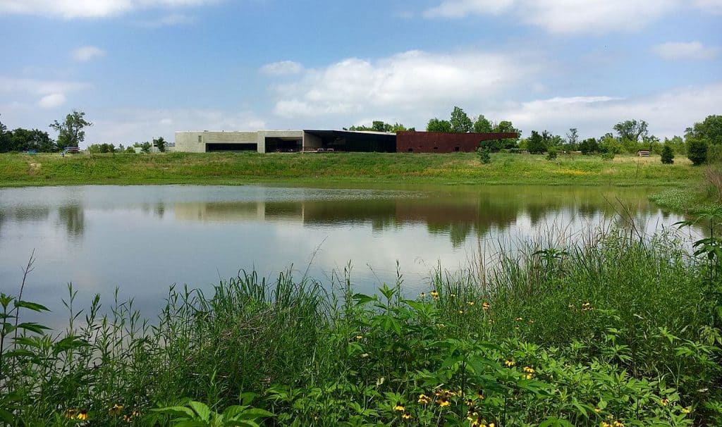 A lake with a building behind it at Trinity River Audubon Center in Texas