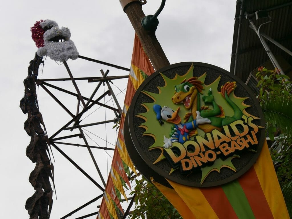 A dinosaur with a Santa hat and beard at Disney World's Animal Kingdom at Christmas