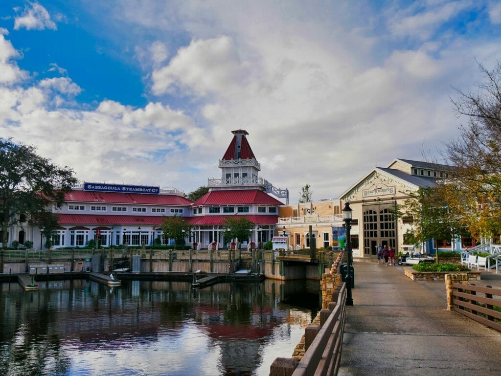 A walkway to a restaurant and red roofed building with a Sassagoula Steamboat company sign