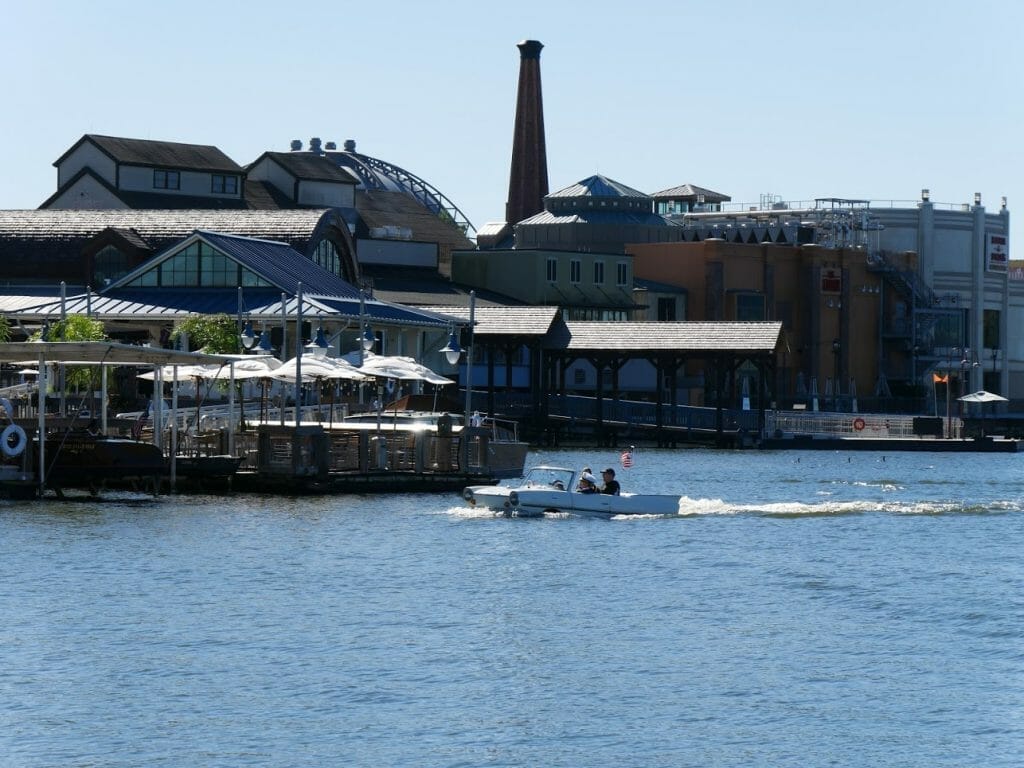 A group of people sailing a car boat on the water at Disney Springs in Disney World