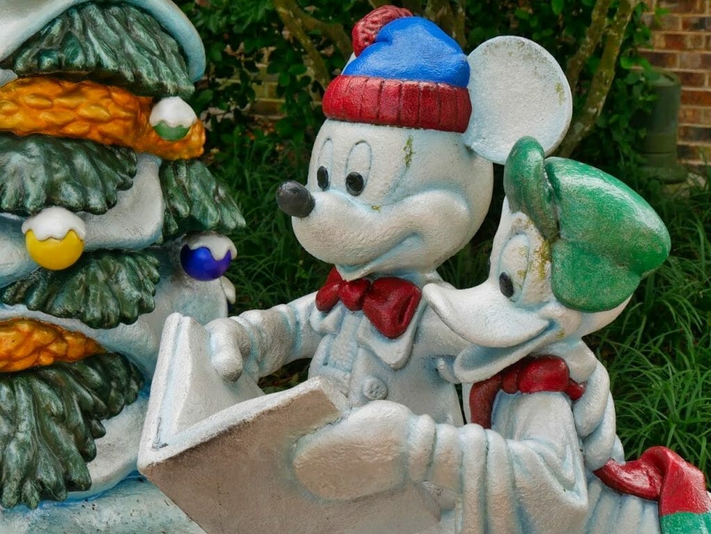 Mickey and Donald as snowmen singing from a Christmas carols book at the Disney Springs Christmas Tree Trail