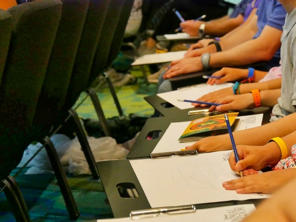 People with paper and pencils at a free animation class at Disney