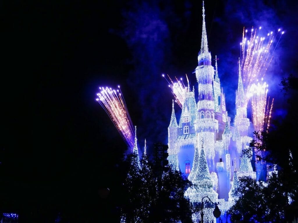 Disney World castle lit up at night with fireworks