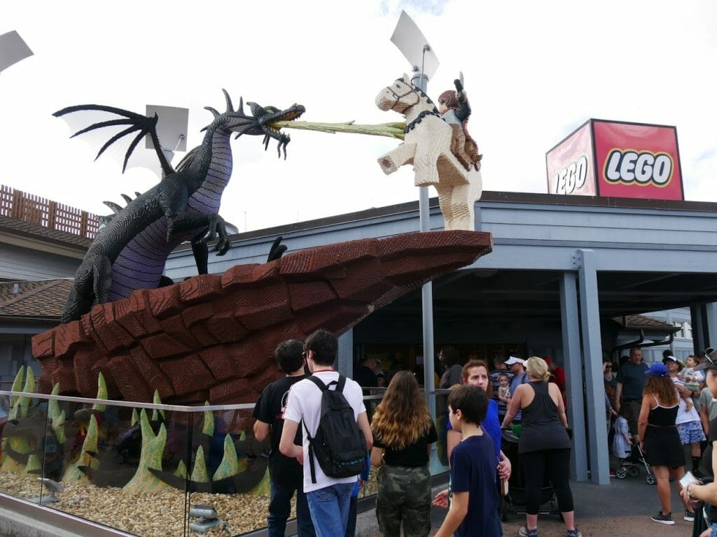 Entrance to the Lego store at Disney Springs with a lego dragon breathing fire and a Lego knight fighting it