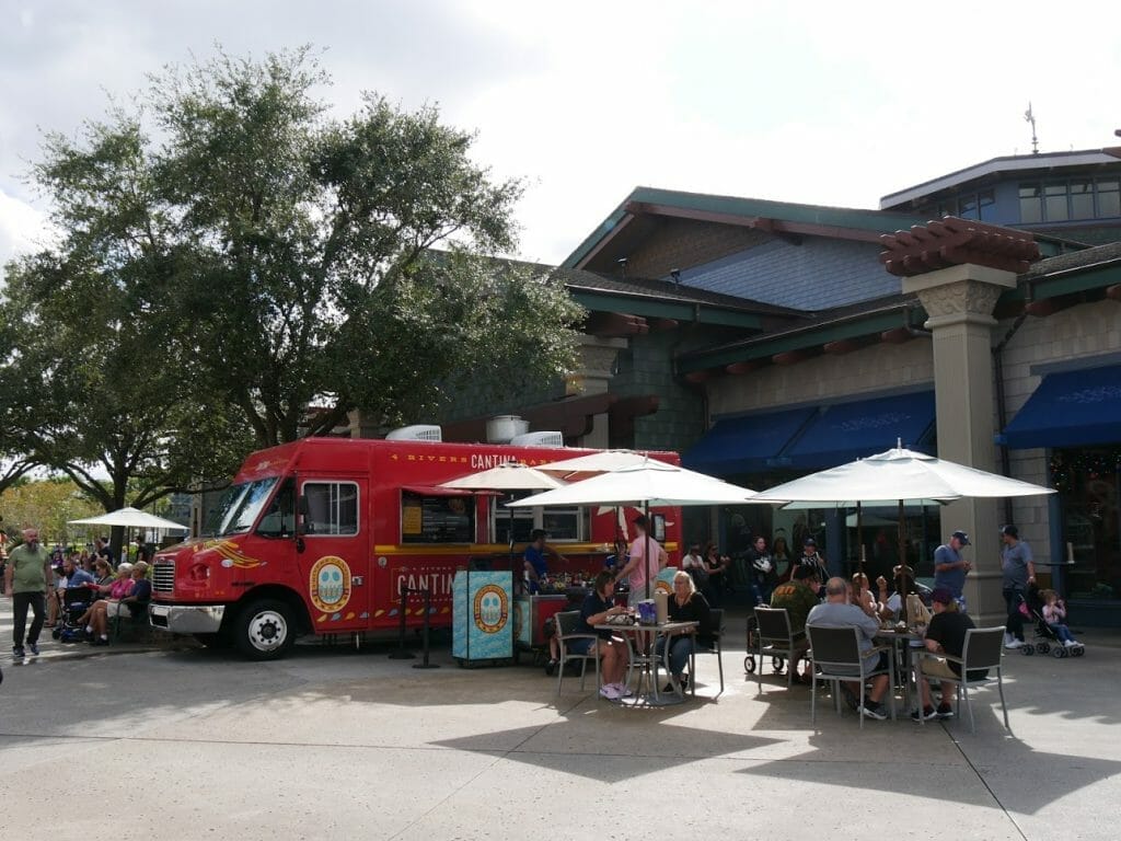 A red food truck with tables outside at Disney Springs