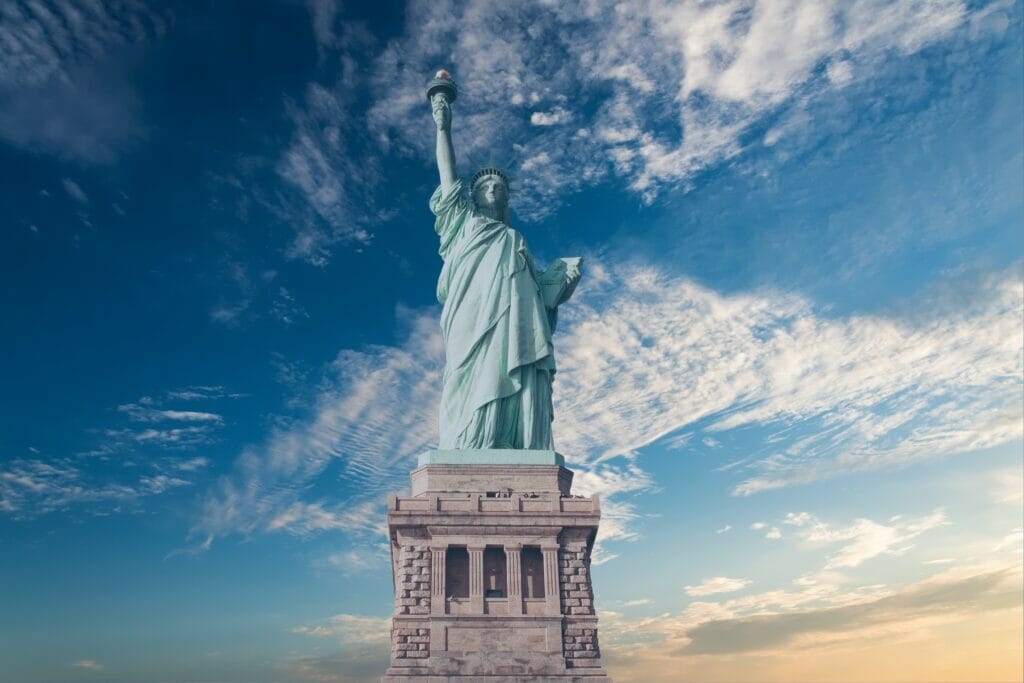 the Statue of Liberty stands tall against a blue sky