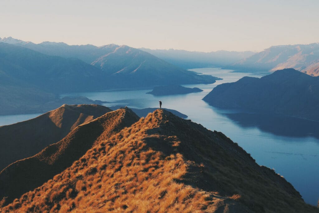 man standing on top of a mountain