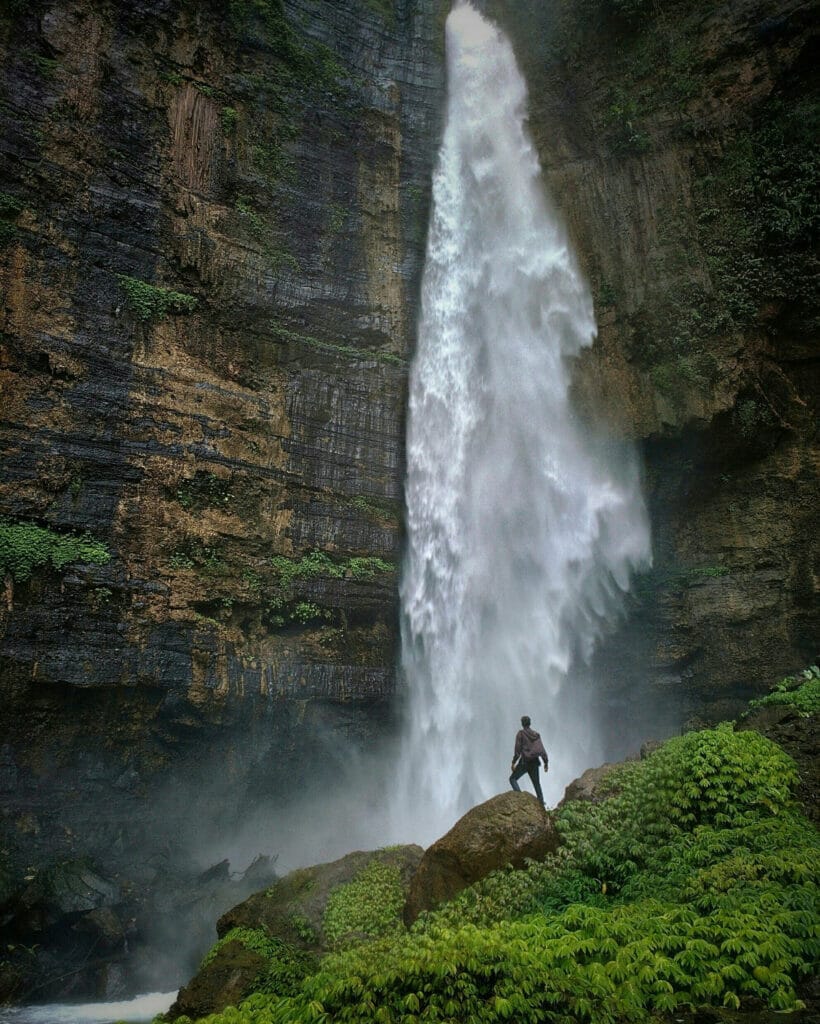 man in front of a waterfall