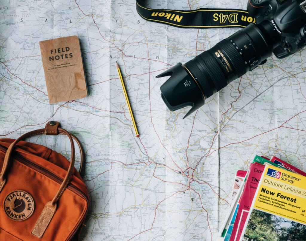 camera, backpack, and field notes on a map.