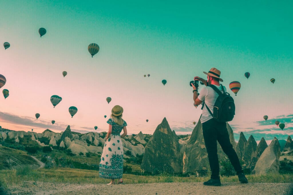 couple taking pictures of hot air balloons.
