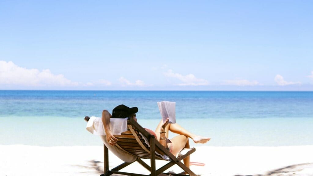 woman reading a book on the beach