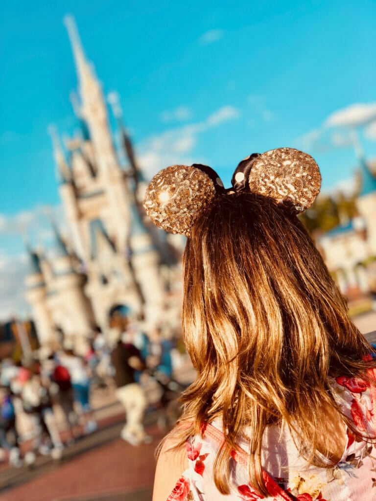 woman with Disney ears looking at castle
