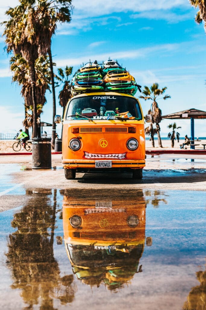 van with surfboards on a beach