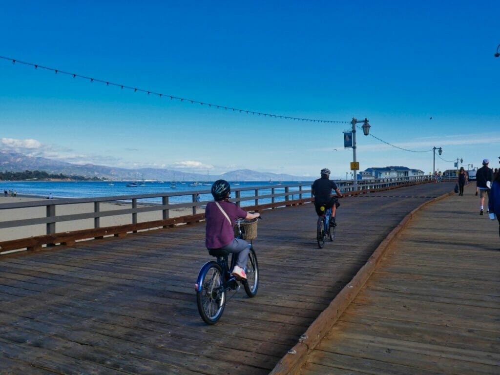 woman cycling down santa barbara pier