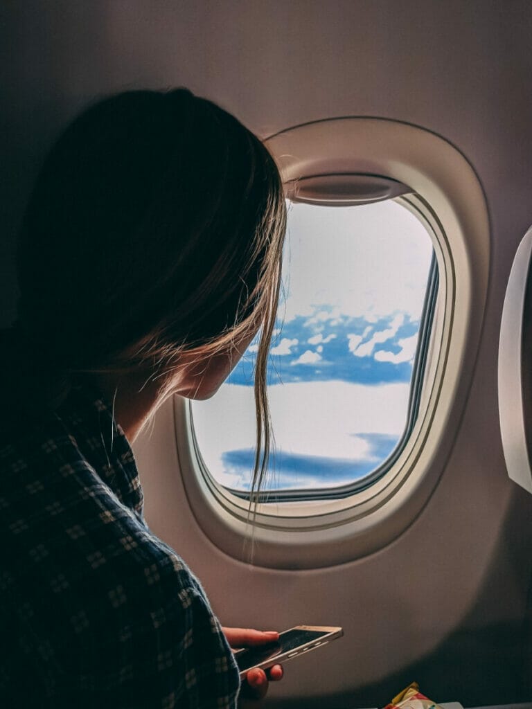 Girl looking out the window on a plane