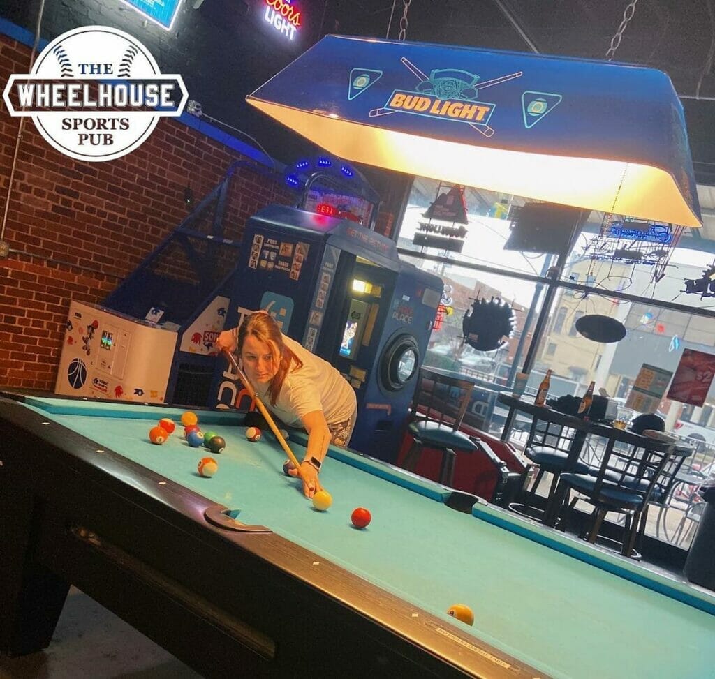 Person playing pool at the Wheelhouse, one of the best pubs in Tuscaloosa