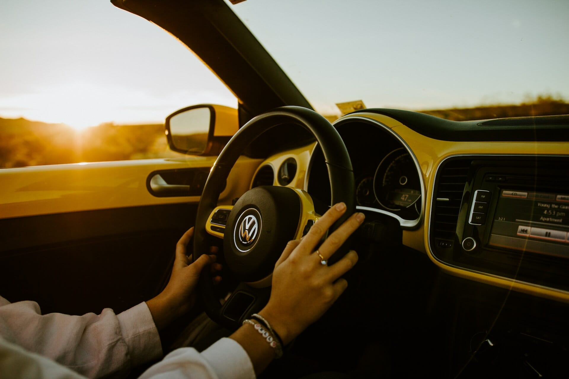 A person driving in a car, with both hands on the wheel.