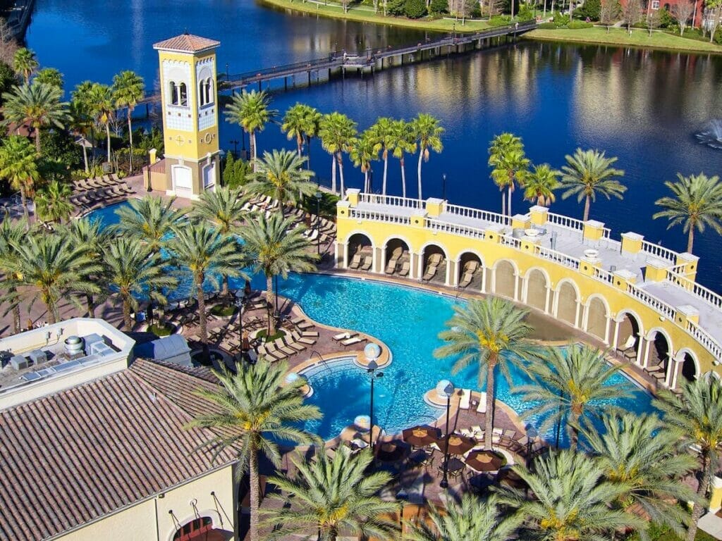 Birds eye view of the beautiful yellow building and clear pool waters at Hilton Grand Vacations at Tuscany Village hotel
