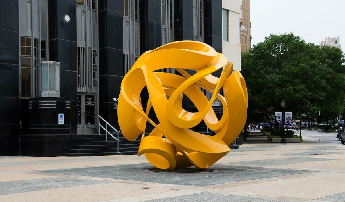 A large, bright yellow abstract sculpture in Fort Worth