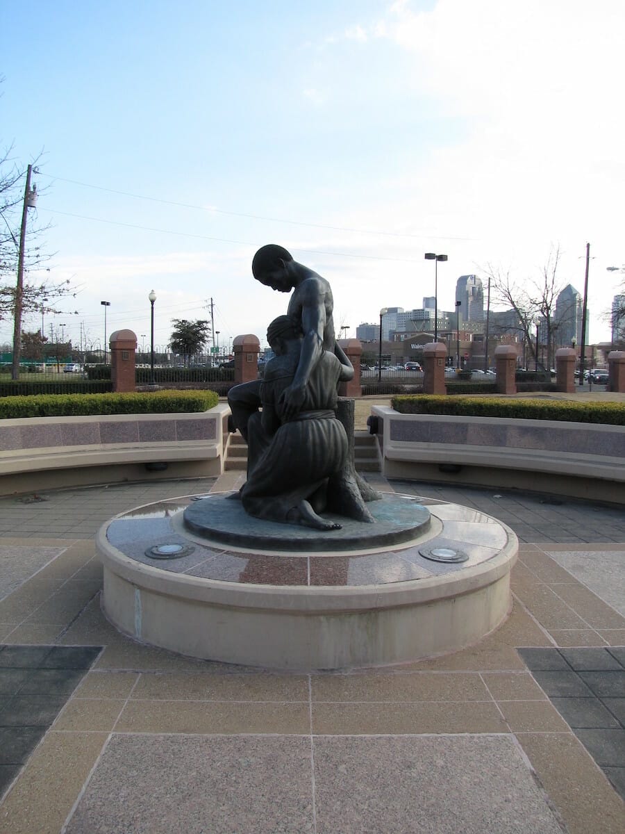 A bronze statue of two people holding on to each other at Freedman's Memorial Cemetery in Dallas