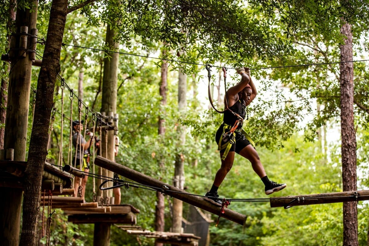 A person braves the heights course at Orlando Tree Trek Adventure Park