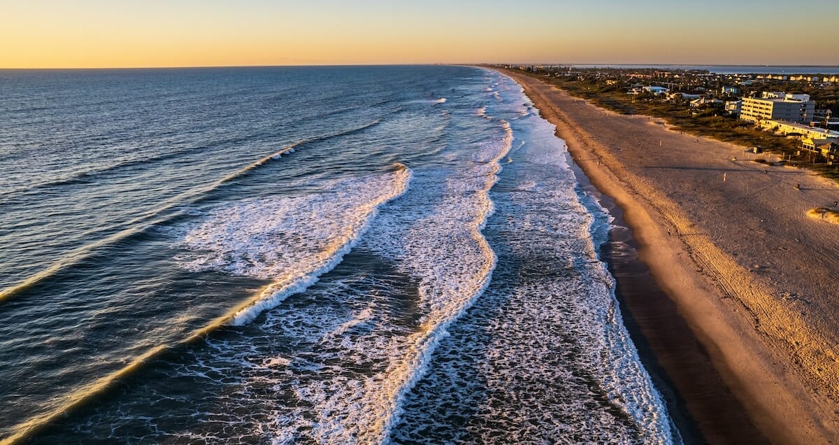 Aerial shot of the ocean and sands at Cocoa Beach, Florida at sunrise