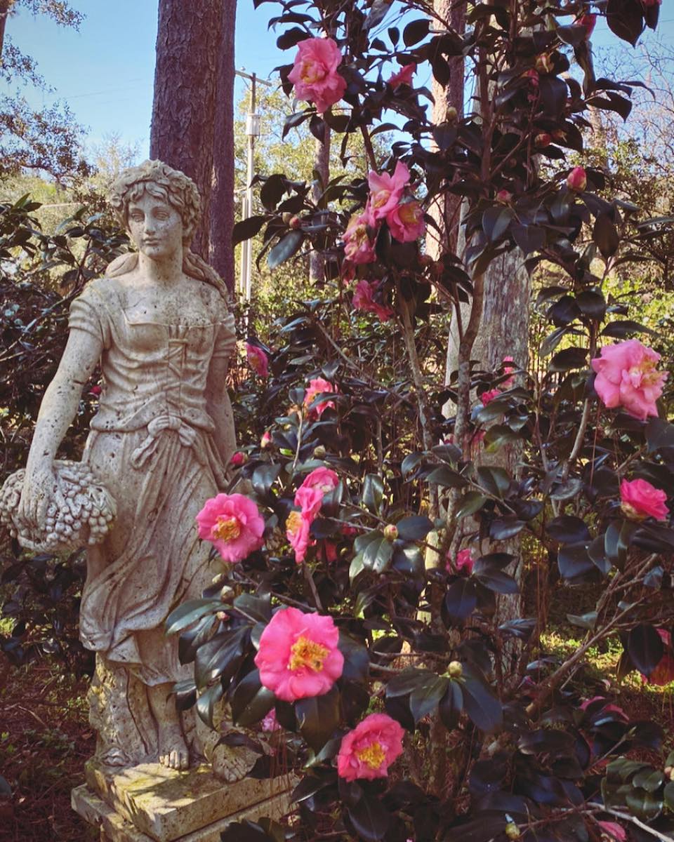 a statue amongst flowers at Mead Botanical Garden near Orlando Florida