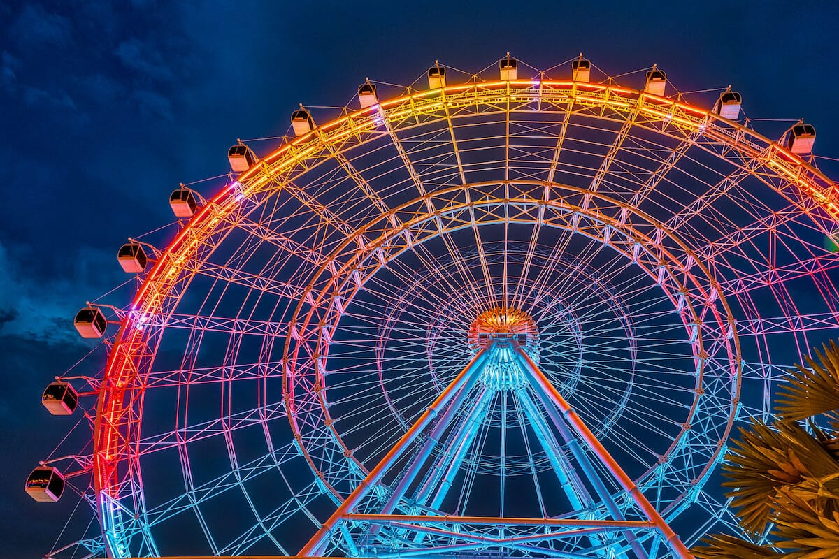 Night view of the Wheel at ICON Park Orlando, lit up in a colorful nighttime display.