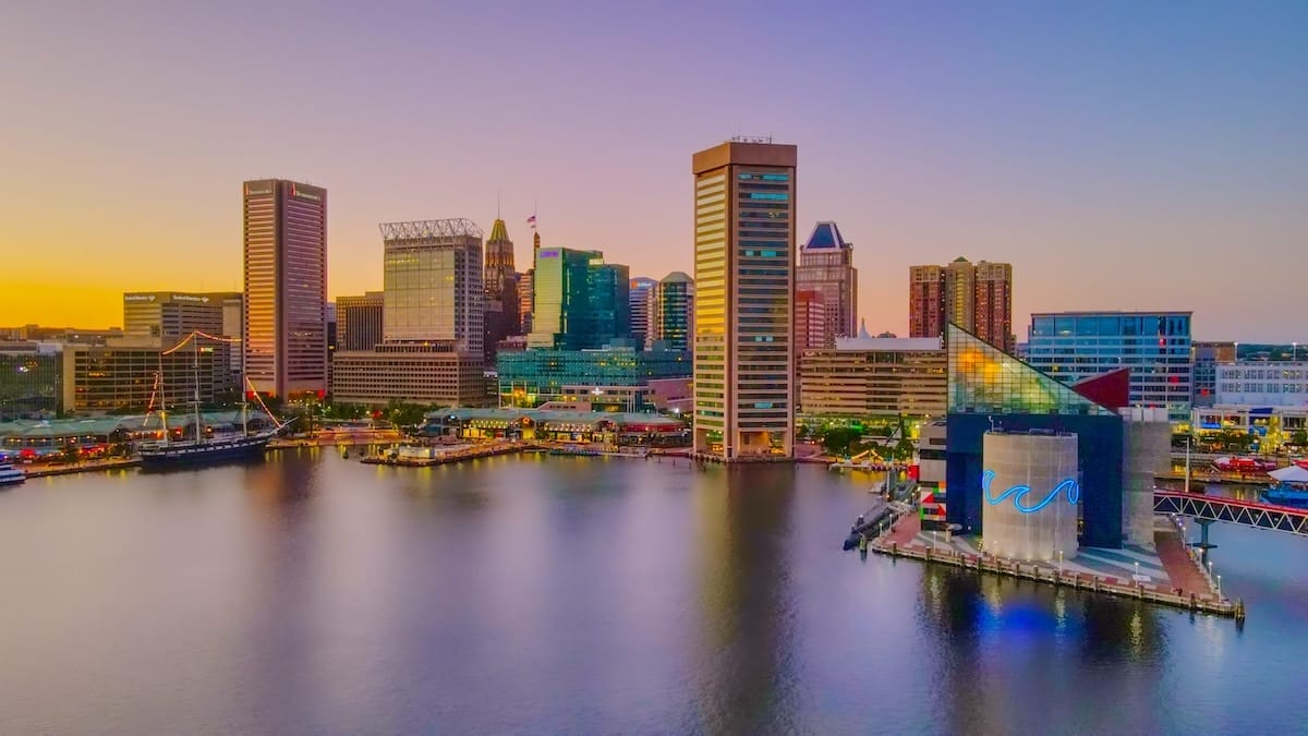 colorful view of Baltimore's inner harbor, featuring skyscrapers amongst a waterfront, making Baltimore one of the most beautiful places in America