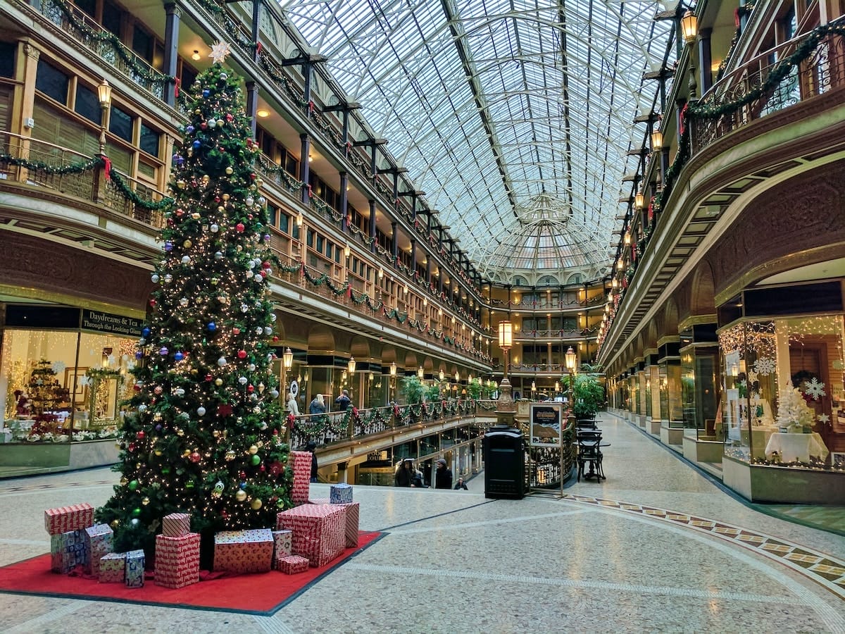 interior of the Cleveland Arcade during the winter holidays, featuring a Christmas tree with lights, and garland along the balconies