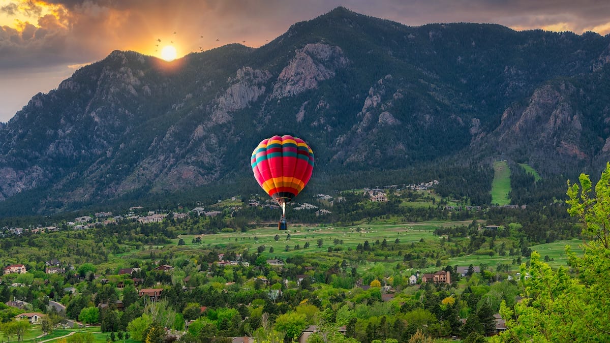 a hot air balloon floats over Colorado Springs, CO