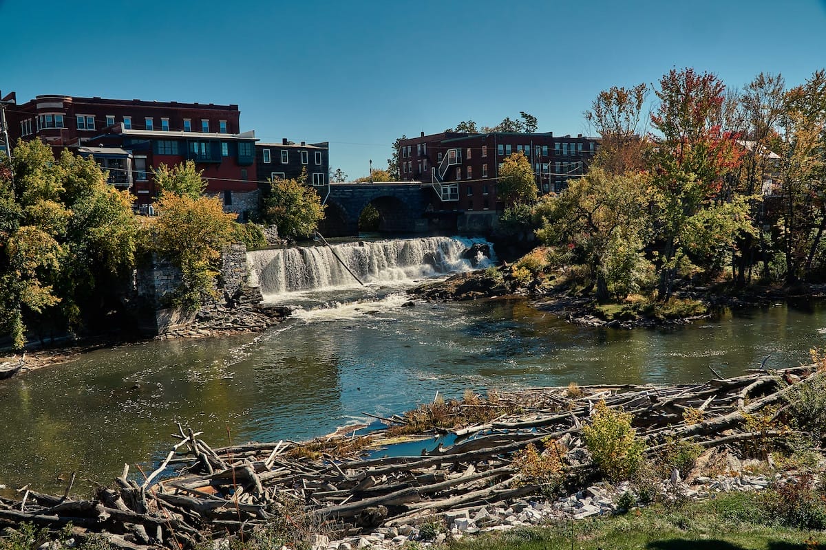brick buildings along the waterfront featuring a waterfall in Old Middlebury, Vermont