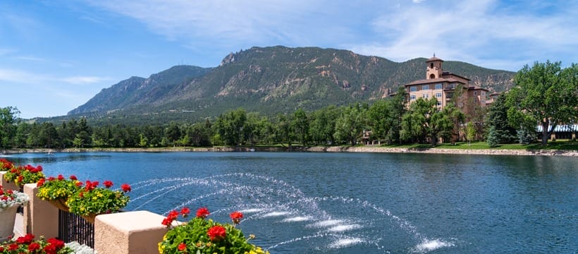 View of The Broadmoor Hotel in Colorado Springs from its back pond, with mountains in the background