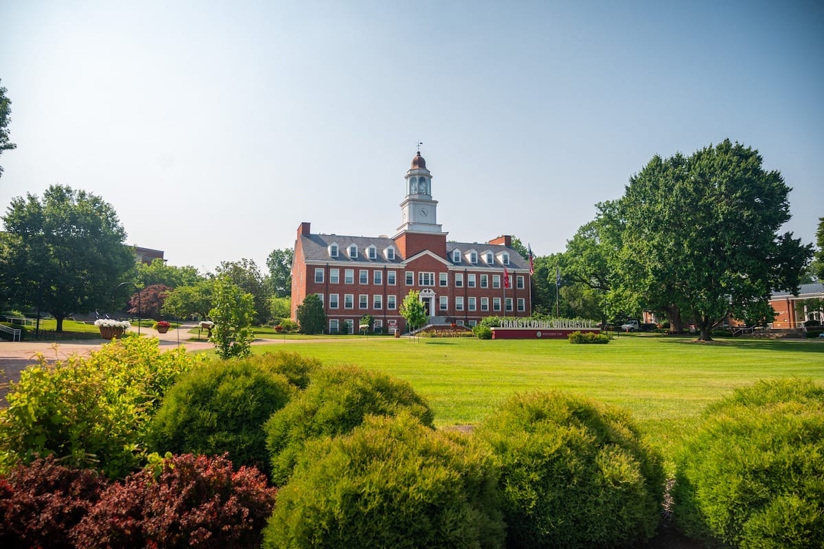 Transylvania University grounds, featuring bright green grass and a historic red brick building