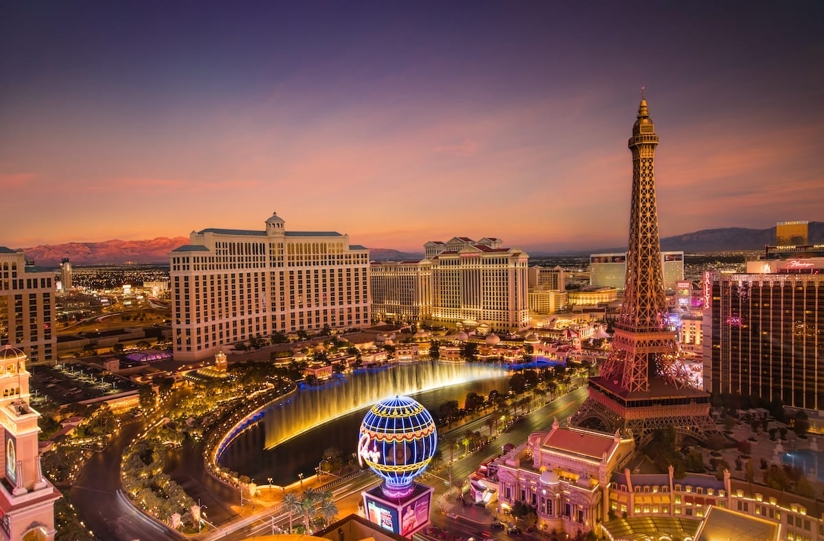 evening view of the Strip in Las Vegas, with glowing lights and a colorful sunset