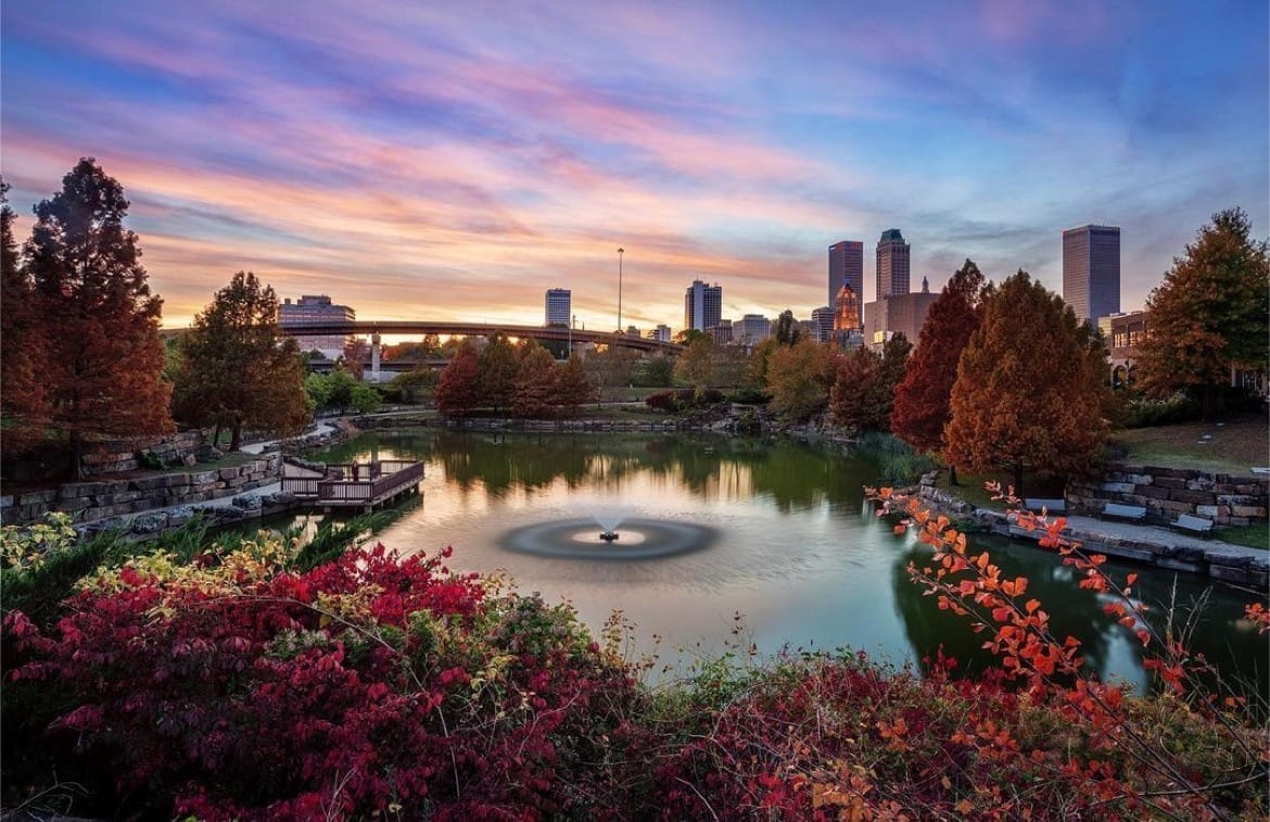 colorful view of downtown Tulsa Oklahoma, featuring a pond fountain in a downtown park