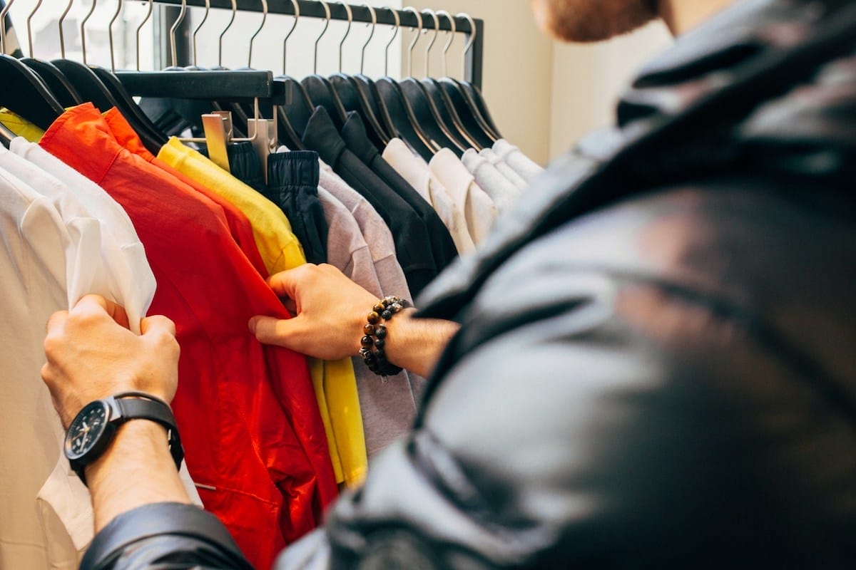 a person browses a clothing rack in a shop