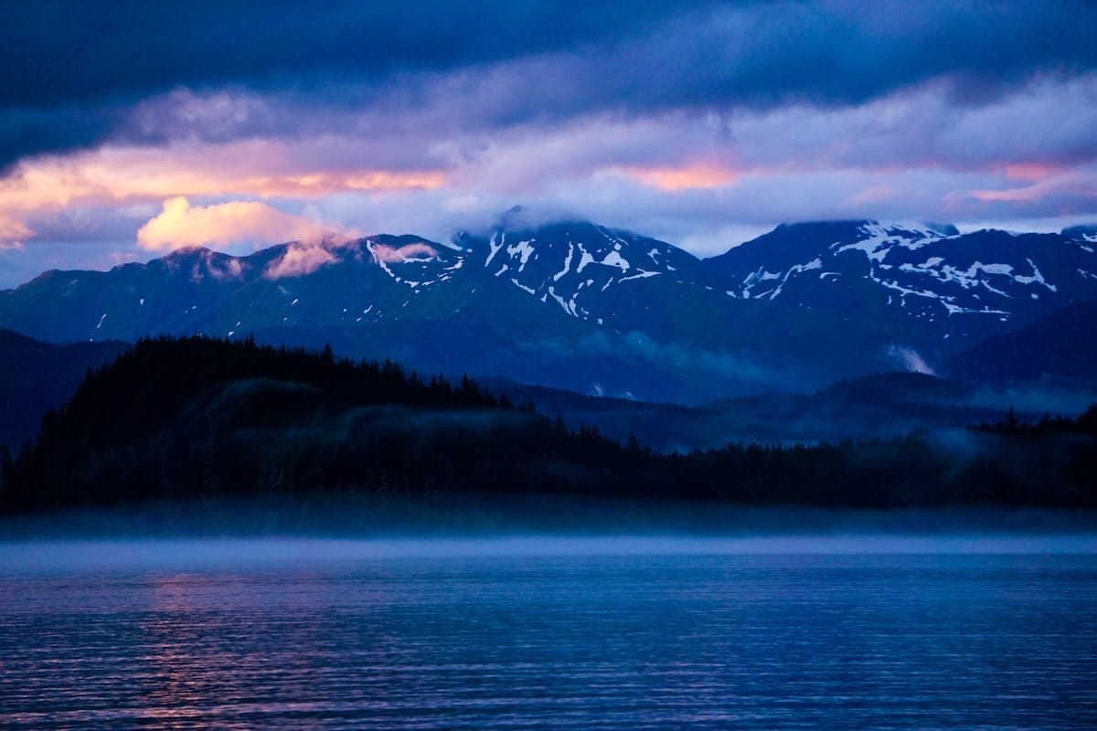 sunset in Juneau Alaska brings cool shades of blue and purple to the mountain backdrop, making it one of the most beautiful places in America