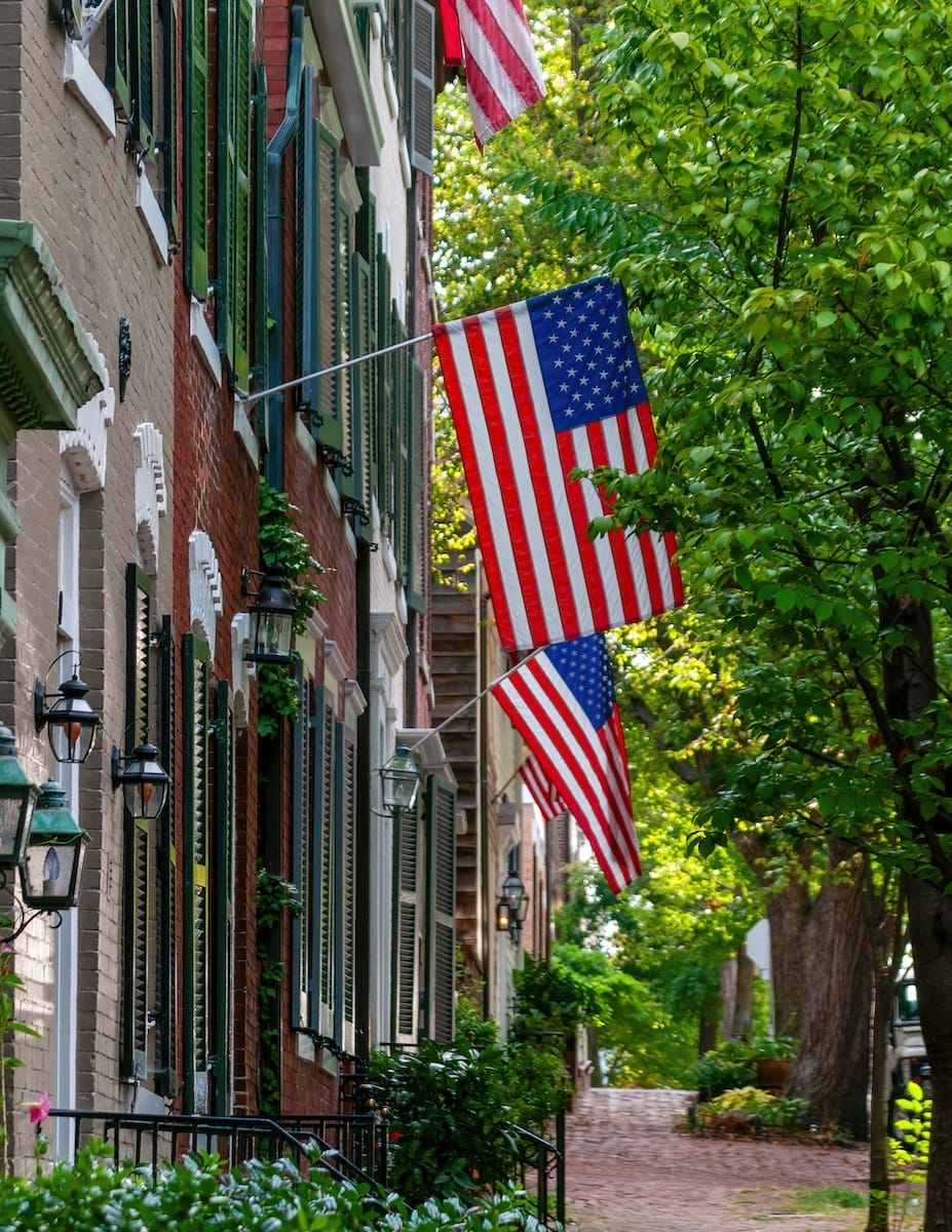 American flags emerge from brick buildings in Old Town Alexandria, Virginia